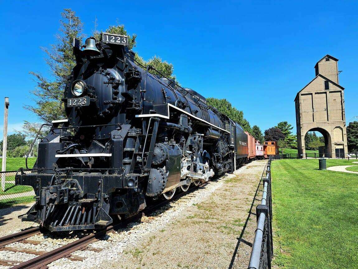 A black train traveling down train tracks next to a building