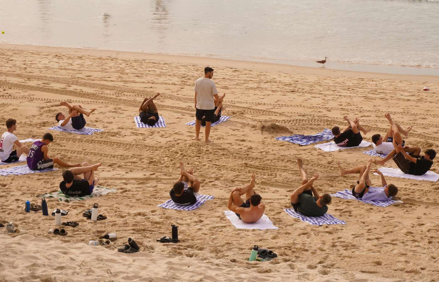 77EfnPCSWWA People are doing yoga exercises on the beach.